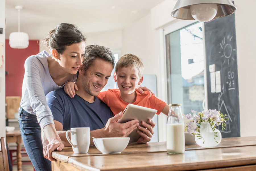 family looking at tablet smiling